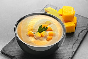 pumpkin cream soup mashed potatoes on a gray background. Vegan curried pumpkin lentil soup puree in a bowl. Space for