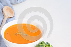 Pumpkin cream soup on a white table. Copy space