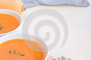 Pumpkin cream soup on a white table. Copy space