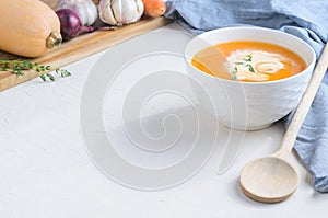 Pumpkin cream soup on a white table. Copy space