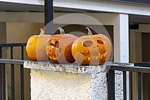 Pumpkin decorations on the fence, carved funny and scary faces. Halloween, All Saints\' Day in Europe.