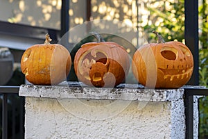 Pumpkin decorations on the fence, carved funny and scary faces. Halloween, All Saints\' Day in Europe.
