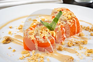 Pumpkin dessert with tahini and walnuts on a white porcelain plate