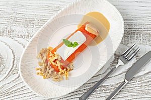 Pumpkin dessert with tahini and walnuts on a white porcelain plate