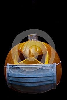 pumpkin with face mask on black background