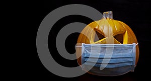 Pumpkin with face mask on black background