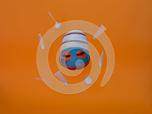 Pumpkin with facial mask and towel levitates in the air, flies on orange background