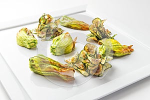 Pumpkin flowers filled with fish with courgette chips