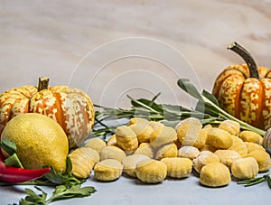 Pumpkin gnocchi with pumpkin pepper lemon herbs on blue wooden background close up