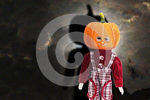 Pumpkin headed doll standing under dark sky looking terrify