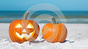 Pumpkin Jack-o`-lantern on the beach.  Jack-o-lantern for Happy Halloween. Autumn season. On background turquoise ocean water. Aut