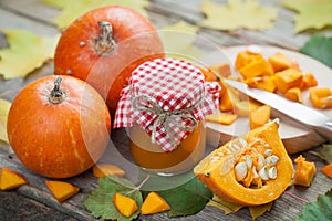 Pumpkin jam, puree or sauce and ripe pumpkins on table