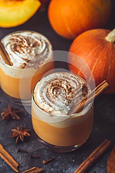 Pumpkin latte drink. Autumn coffee with spicy pumpkin flavor and cream on a dark background. Seasonal Fall Drinks for Halloween