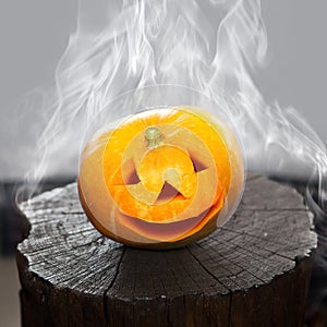 Pumpkin that laughs on a charred stub in smoke