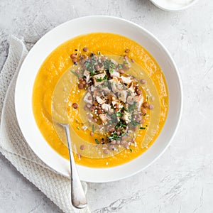 Pumpkin and lentil cream soup in white bowl