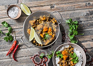 Pumpkin lentil curry and rice on a wooden table, top view. Indian vegetarian food