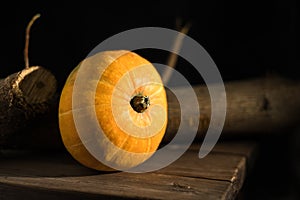 The pumpkin is orange on a dark background. Wooden board