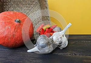 Pumpkin pepper and garlic on yellow background. preparing for Halloween