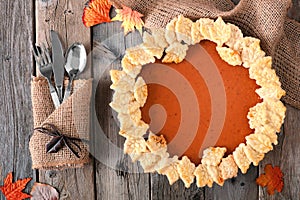 Pumpkin pie with autumn leaf pastry design, overhead table scene