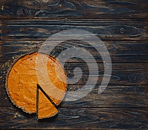 Pumpkin pie on dark brown background