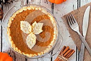 Pumpkin pie with leaf pastry toppings on rustic wood