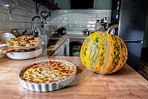 Pumpkin Pie Quiche Tart and ripe pumpkin on the kitchen table