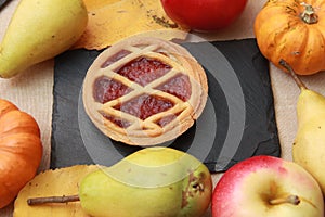 pumpkin pie and seasonal fruits and vegetables on wooden background