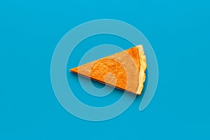 Pumpkin pie slice isolated on a blue background