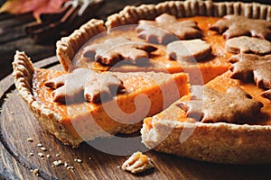 Pumpkin pie sliced on wooden board. Closeup view