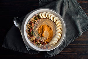 Pumpkin Pie Smoothie Bowl on a Wooden Table with a Spoon