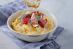 Pumpkin porridge with rice, raspberries and fresh figs. Autumn food.