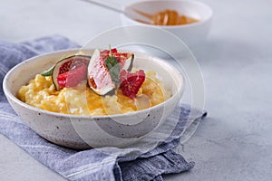 Pumpkin porridge with rice, raspberries and fresh figs. Autumn food.