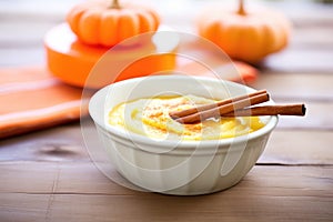 pumpkin pudding in bowl with cinnamon stick