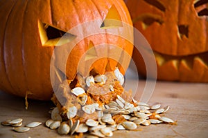 Pumpkin puking with pumpkin seeds on wood table