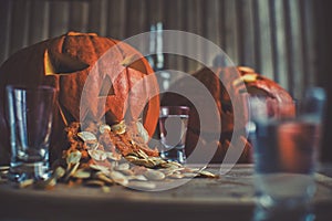 Pumpkin puking with pumpkin seeds on wood table, vodka, hdr effect