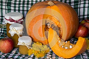 Pumpkin and pumpkin jam, puree or sauce on green with white tablecloth. Autumn still life.