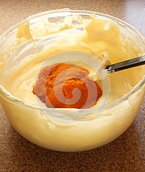 Pumpkin puree being incorporated into batter