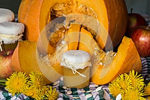 Pumpkin puree or jam on a background of cut pumpkin. Autumn still life.