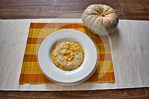 Pumpkin risotto in a white plate with the pumpkin decoration