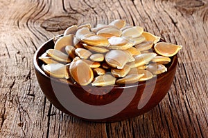 Pumpkin seeds in a plate on wooden table