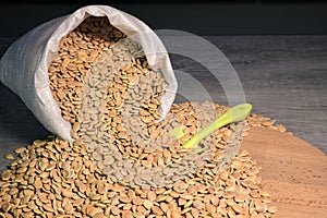 Pumpkin seeds are poured out of the bag onto the board