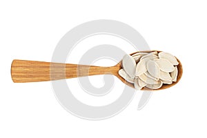 Pumpkin seeds in wood spoon isolated on white background. File contains clipping path. Top view