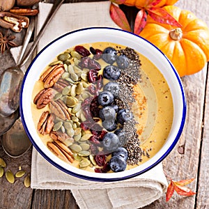 Pumpkin smoothie bowl with chia seeds, pecans, cranberries