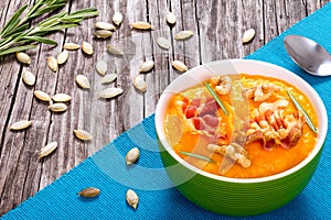 Pumpkin soup with bacon, walnut, pumpkin seeds and rozemary photo