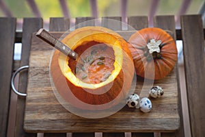 Pumpkin soup in a bowl with fresh pumpkins, garlic and parsley herbs