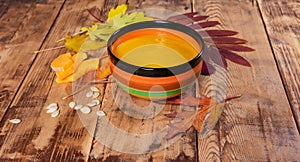 Pumpkin soup bowl on rustic wooden background