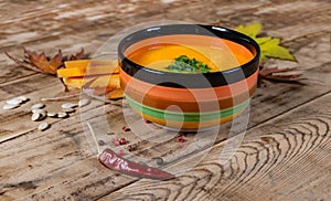 Pumpkin soup bowl on rustic wooden background