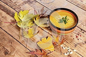 Pumpkin soup bowl on rustic wooden background