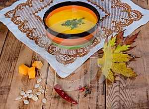 Pumpkin soup bowl on rustic wooden background