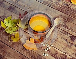 Pumpkin soup bowl on rustic wooden background